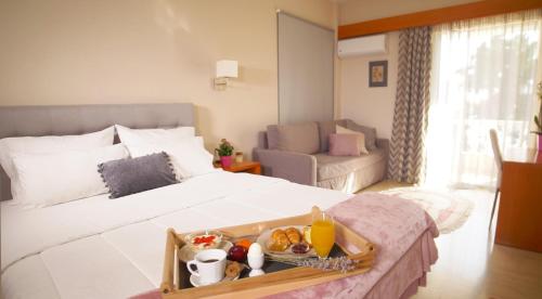a hotel room with a bed with a tray of food on it at Antikyra Beach Hotel in Antikyra