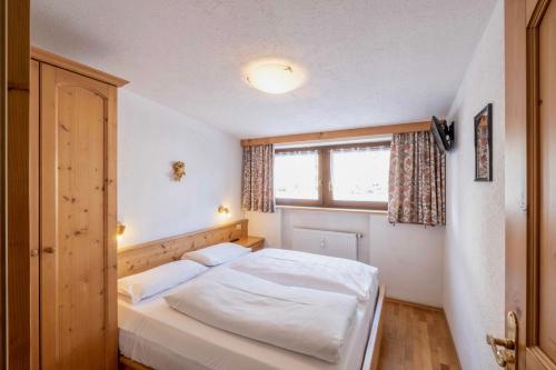 a bedroom with a white bed and a window at Residence Salvan in Corvara in Badia