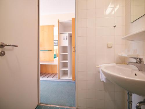 a bathroom with a sink and a mirror at Sportschule Oberhaching in Oberhaching