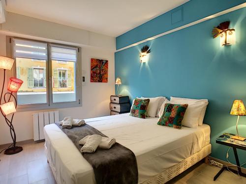 a bedroom with a large bed with a blue wall at Nestor&Jeeves - CIGALUSA TERRASSE - Port area - Close Old Town in Nice