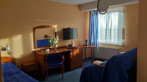 una stanza d'albergo con una scrivania e uno specchio di Willa Zbyszko a Danzica