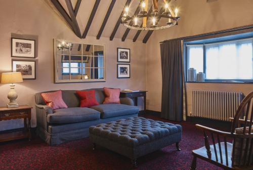 a living room with a couch and a chair at The Lygon Arms - an Iconic Luxury Hotel in Broadway