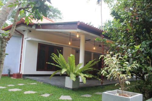 a house with a garden in front of it at Sea Close Inn in Ahangama