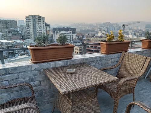 a table and chairs on a ledge with potted plants at VeraNda in Tbilisi City