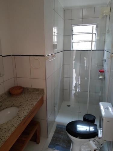 a bathroom with a shower and a toilet and a sink at Flat 47 SUN HOUSE Maresias in Maresias