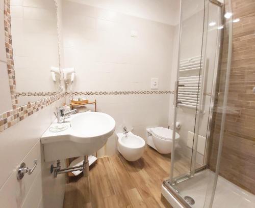 a white bathroom with a sink and a toilet at B&B Floridiana in Naples