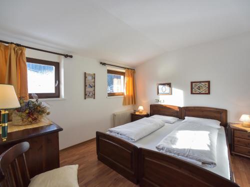 a bedroom with a bed and a desk and window at Residence Salvan in Corvara in Badia