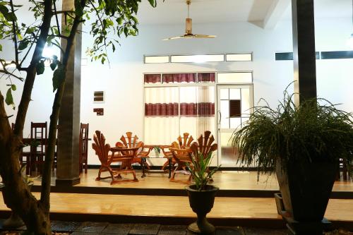 a room with chairs and a table in a building at Dearly Holiday Home And Safari in Tissamaharama