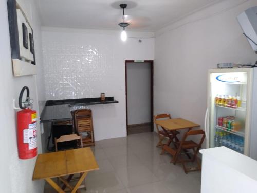 a room with a fire hydrant and a table and chairs at Pousada Vitória in Aparecida