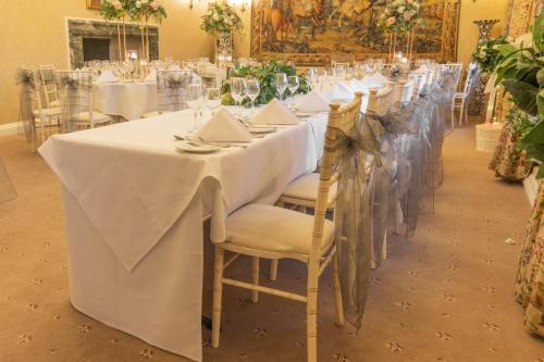 a long table with white table cloths and chairs at Castle Bromwich Hall; Sure Hotel Collection by Best Western in Birmingham