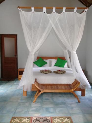 a bedroom with a bed with a mosquito net at Loka Amertha in Sidemen