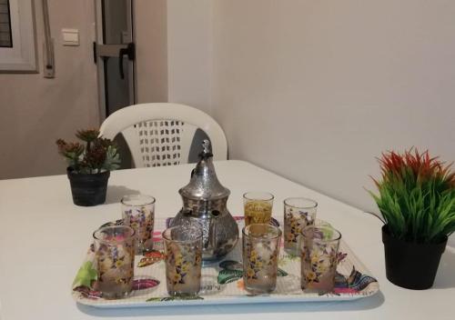a tray with cups and a tea kettle on a table at Appart Hotel Tanger Paname in Tangier
