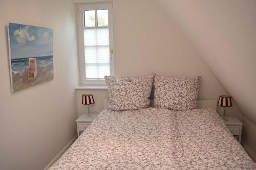 a bedroom with a bed with two pillows and a window at Ferienwohnung-Clarissa in Morsum