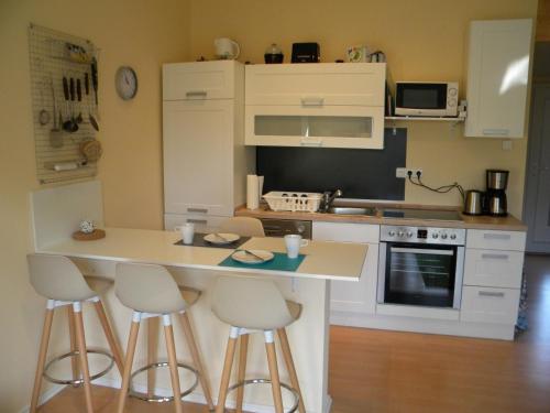 una pequeña cocina con barra y taburetes en Business Apartment/Ferienwohnung (z. CGN/FFM), en Ellenhausen