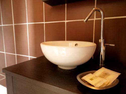 a bathroom with a bowl sink on a counter at L'Alzire - Auberge Culturelle in Jarnages