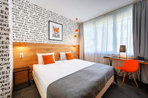 a hotel room with a bed and a desk and a chair at Roombach Hotel Budapest Center in Budapest
