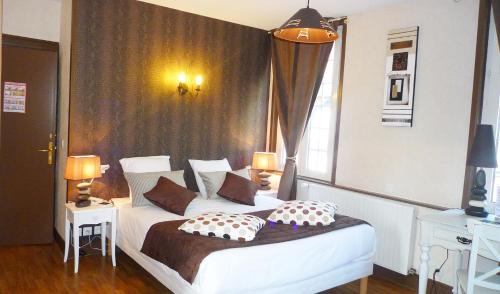 a bedroom with a bed with two pillows on it at Logis Hôtel Restaurant Spa L'auberge Du President in Cormeilles