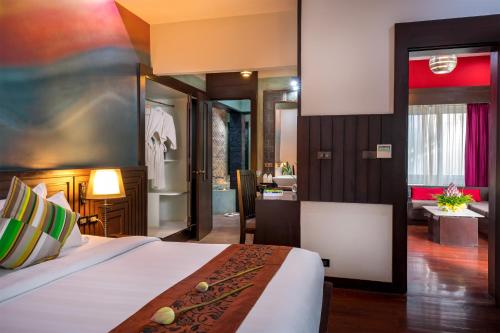 a hotel room with a bed and a bathroom at De Sarann Villa in Siem Reap