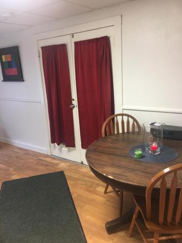 a dining room with a wooden table and red curtains at Art Gallery Hostel in Whitefield