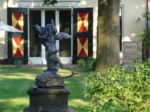 a statue of a girl holding a bird on a rock at Kasteel Sterkenburg in Driebergen