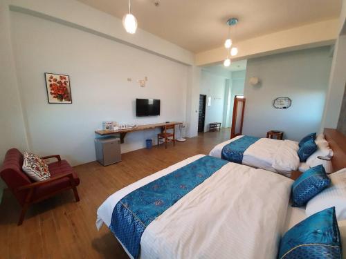 a hotel room with two beds and a television at Clare Holiday B&B in Checheng