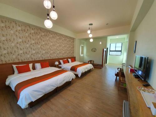 a hotel room with two beds and a television at Clare Holiday B&B in Checheng