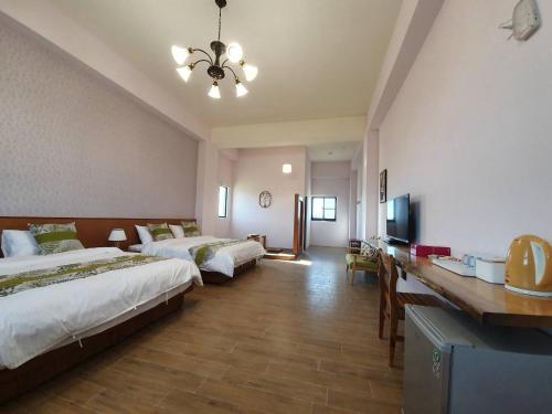 a hotel room with two beds and a television at Clare Holiday B&B in Checheng