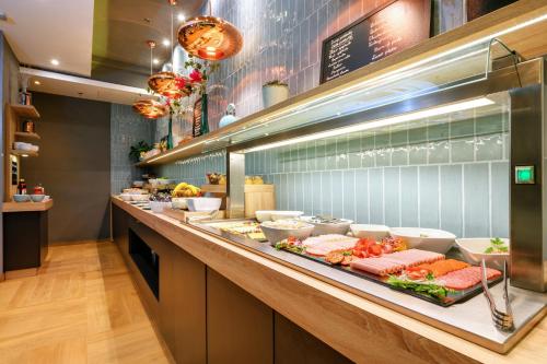 a buffet line in a restaurant with food on it at Roombach Hotel Budapest Center in Budapest