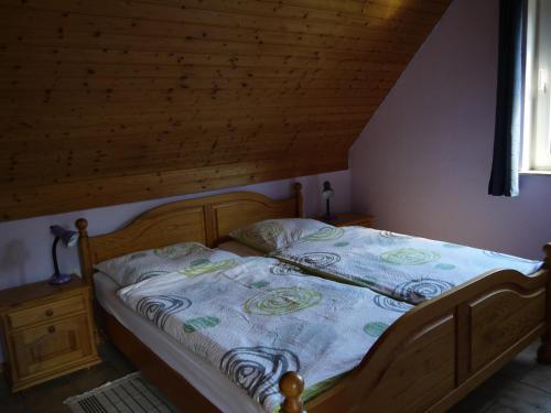 1 dormitorio con cama de madera y manta azul en Ferienwohnungen am Campingplatz, en Trendelburg