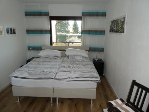 a bed in a small room with a window at Ferienwohnung WällerAuszeit in Nisterau