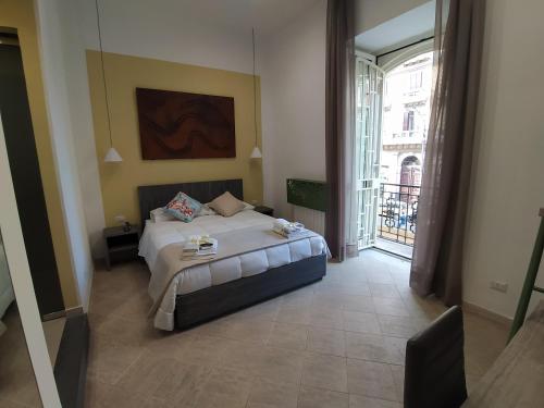 - une chambre avec un lit et une grande fenêtre dans l'établissement La Casa di Halley, à Naples