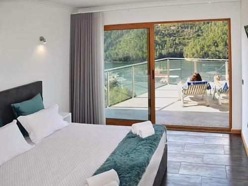 a hotel room with a bed and a balcony at Solar do Cávado in Vieira do Minho