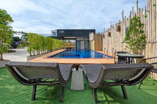 a patio with two chairs and a swimming pool at The Beach at Klong Muang in Klong Muang Beach