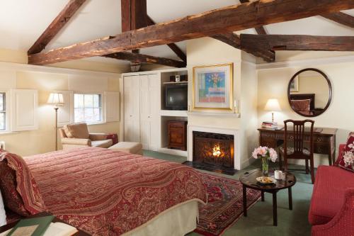a bedroom with a king sized bed and a fireplace at Harbor Light Inn in Marblehead