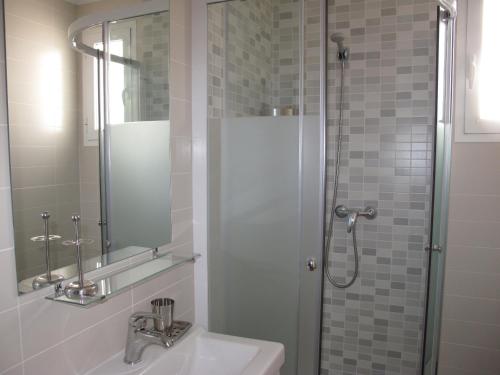 een badkamer met een wastafel en een douche met een spiegel bij Hernan Cortes in Nerja
