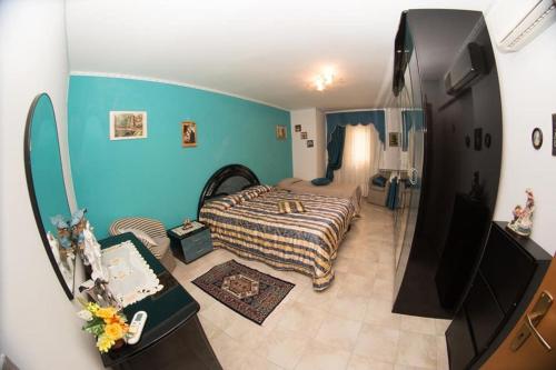 1 dormitorio con cama y pared azul en B&b cuore di sicilia, en Santa Caterina Villarmosa