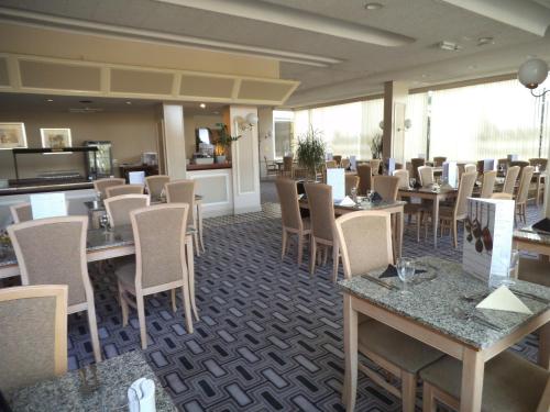 a dining room filled with tables and chairs at Airport Inn Gatwick in Horley