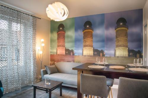ein Esszimmer mit einem Tisch und einem Wandbild des Leuchtturms in der Unterkunft TURGOT #80 - L'Appart. 100% Gaillard - 2 chambres in Brive-la-Gaillarde