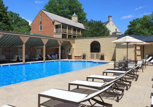 a swimming pool with lounge chairs and an umbrella at Boar's Head Resort in Charlottesville