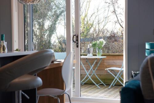 an open door to a patio with a table and chairs at The Levels, Strawberryfield Park, Cheddar in Cheddar