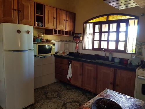 a kitchen with a white refrigerator and a window at Casa Litoral Sul - Praia Bela/ PB in Pitimbu