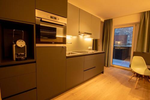 a kitchen with a sink and a stove top oven at Wally Berg-Appartements in Zams