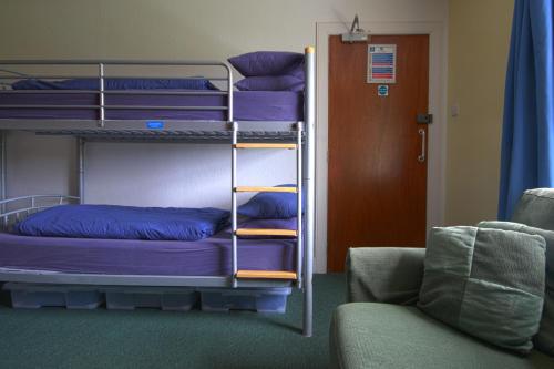 a room with two bunk beds and a couch at Achmelvich Beach Youth Hostel in Achmelvich