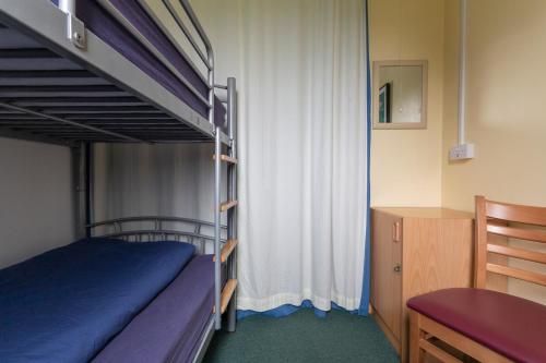 a bedroom with a bunk bed with a desk and a table at Achmelvich Beach Youth Hostel in Achmelvich