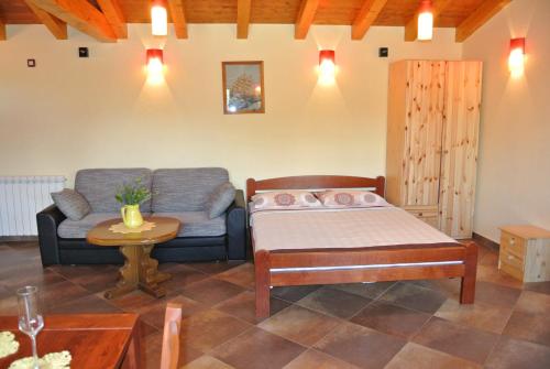 a bedroom with a bed and a couch and a table at VILLA ANCORA MEDULIN in Medulin