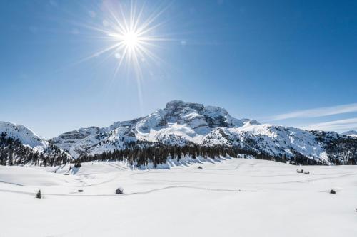 a snow covered mountain with the sun in the sky at Hohe Gaisl in Braies
