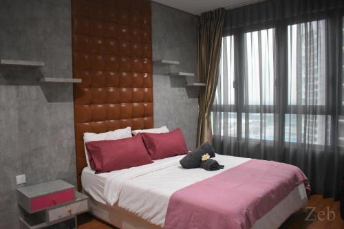 Un dormitorio con una cama con un osito de peluche encima. en i-City-Casa Rosa - Wifi - Netflix - Movies - Parking - Sleeps 5 pax, en Shah Alam