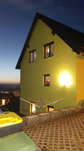 Una gran casa amarilla con ventanas laterales. en Ferienwohnung S. Armbruster, en Bernsbach