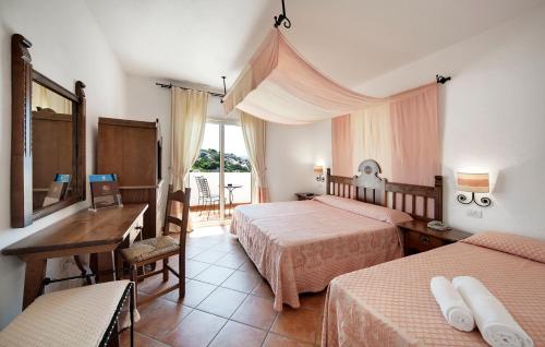 a hotel room with two beds and a desk and a window at Colonna Grand Hotel Capo Testa in Santa Teresa Gallura