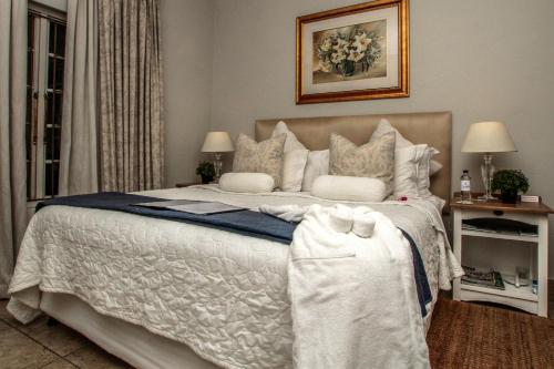 a bedroom with a large bed with white sheets and pillows at Sandals Guest House in Durban